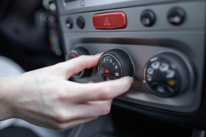 Woman hand turning on car air conditioning system, car air conditioner on off button close up view Woman hand turning on car air conditioning system, car air conditioner on off button close up view